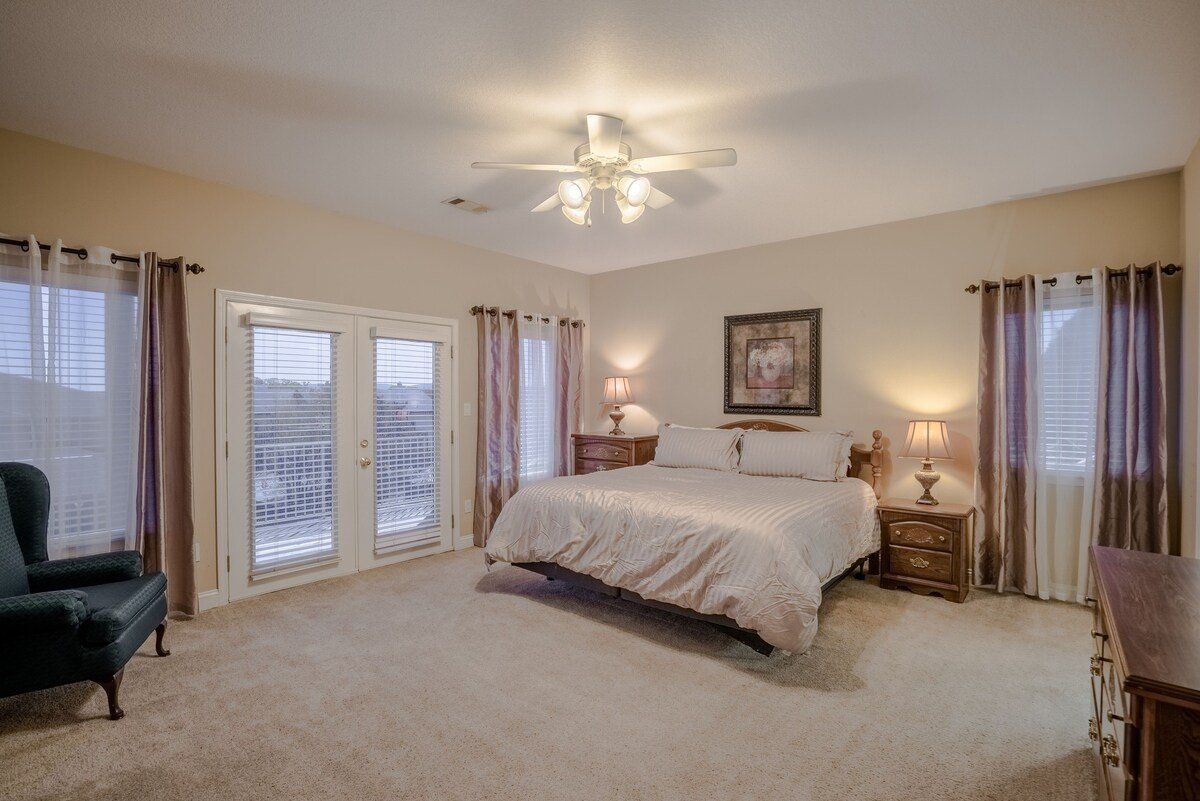 A large bedroom with a king size bed and a ceiling fan.