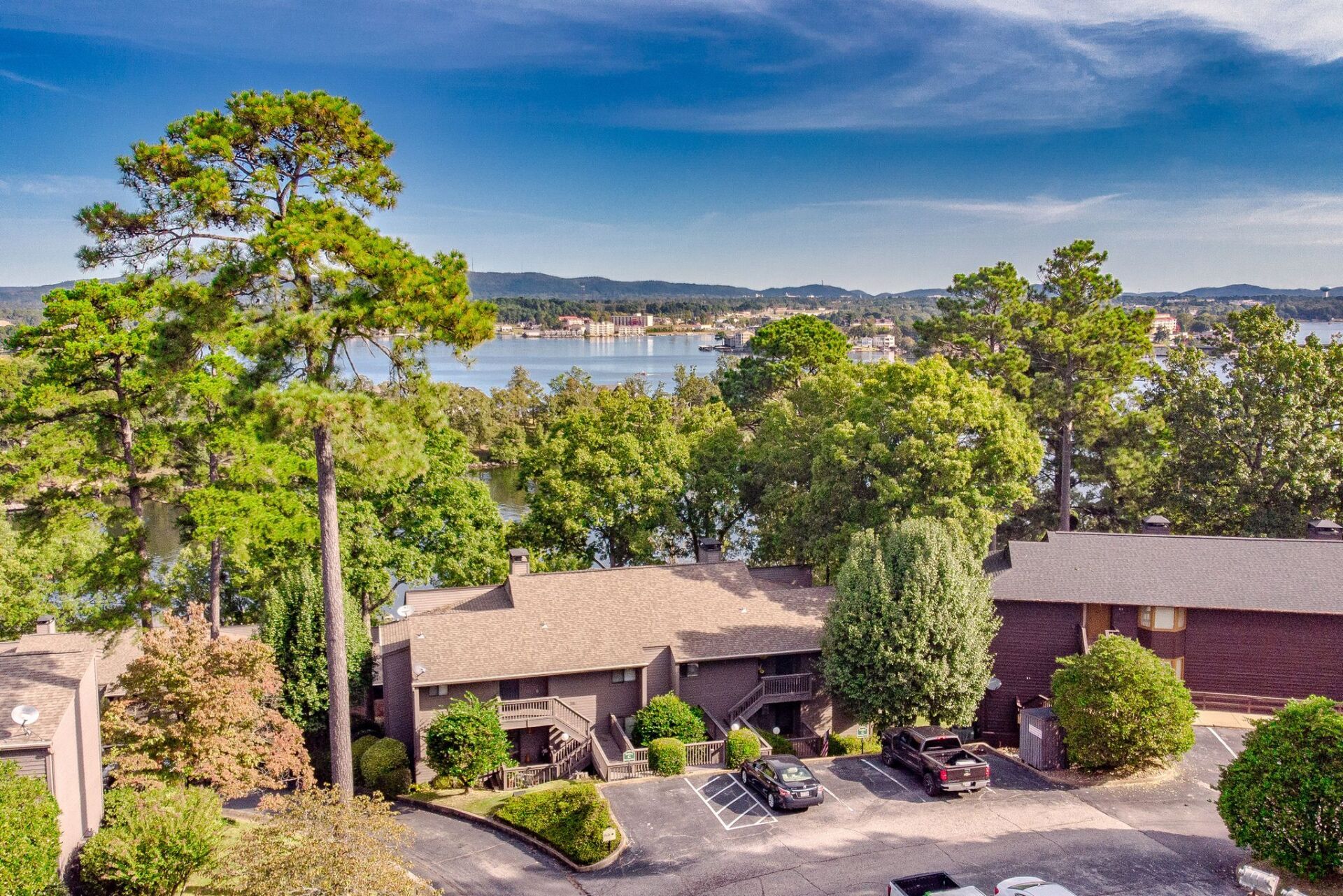 An aerial view of a house surrounded by trees and a lake.