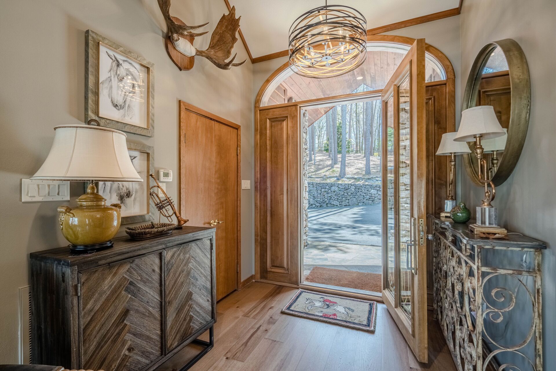 A hallway with a dresser , lamps , and a mirror.