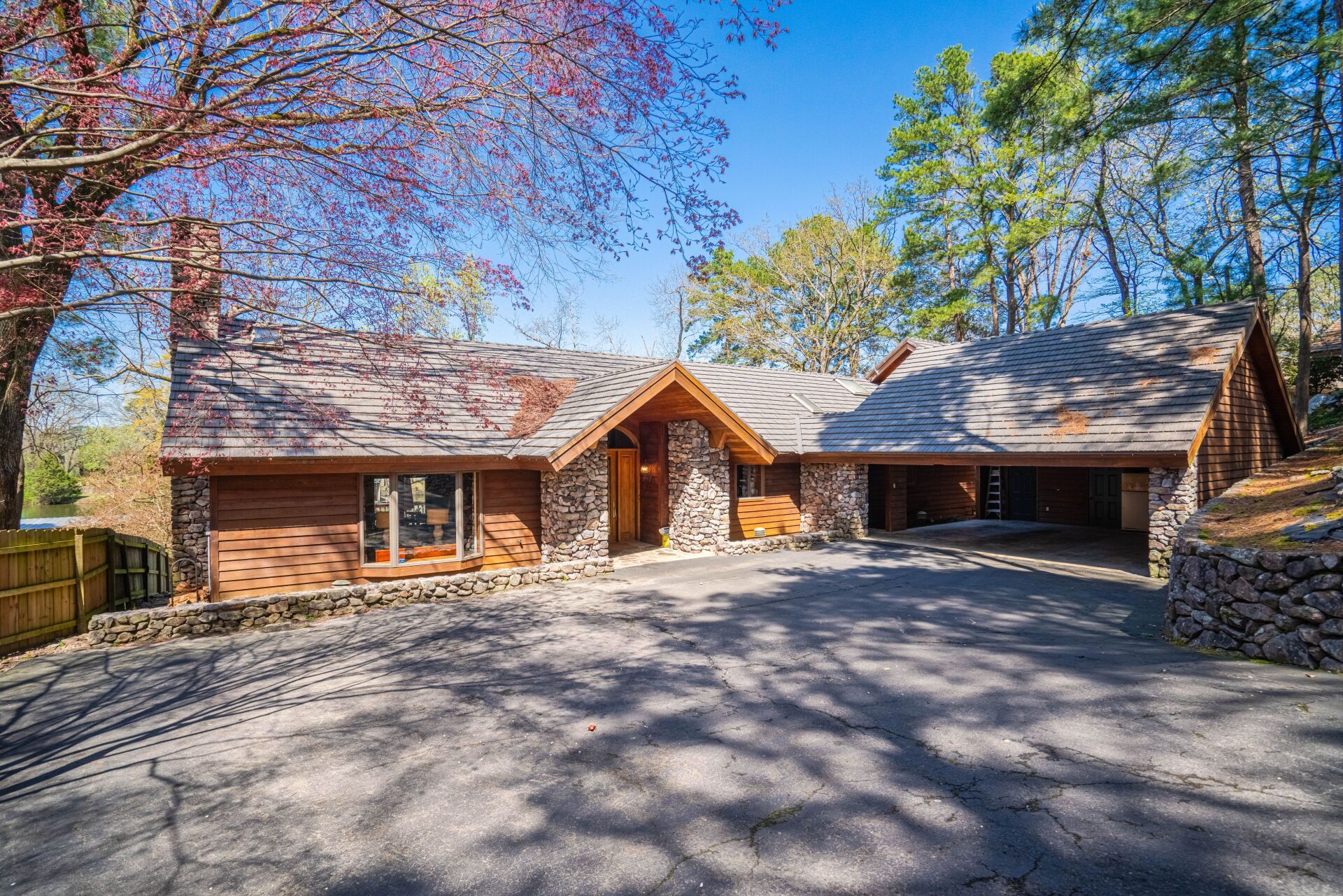 A large house with a driveway and trees in the background.