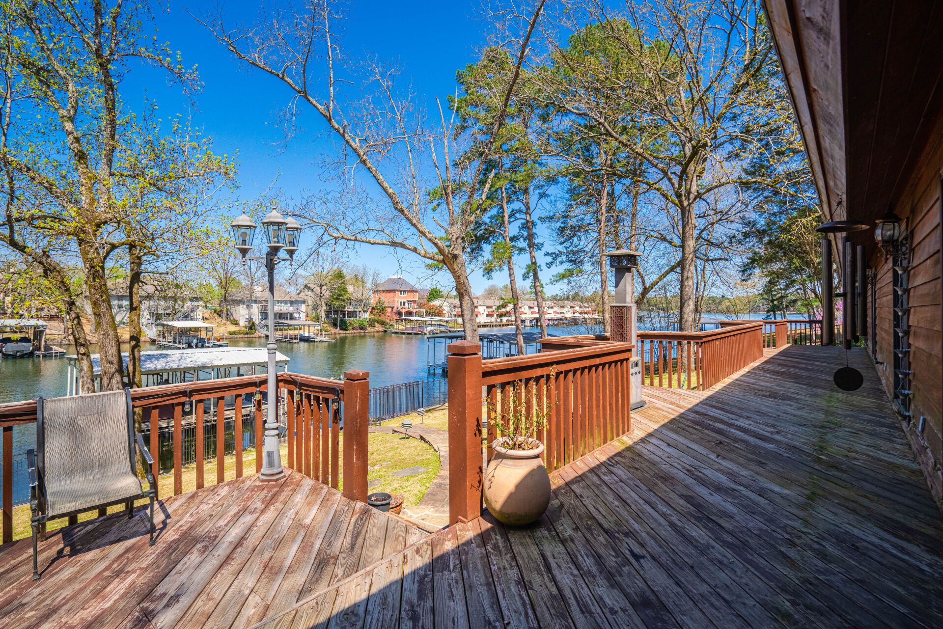 A wooden deck with a view of a lake and trees.