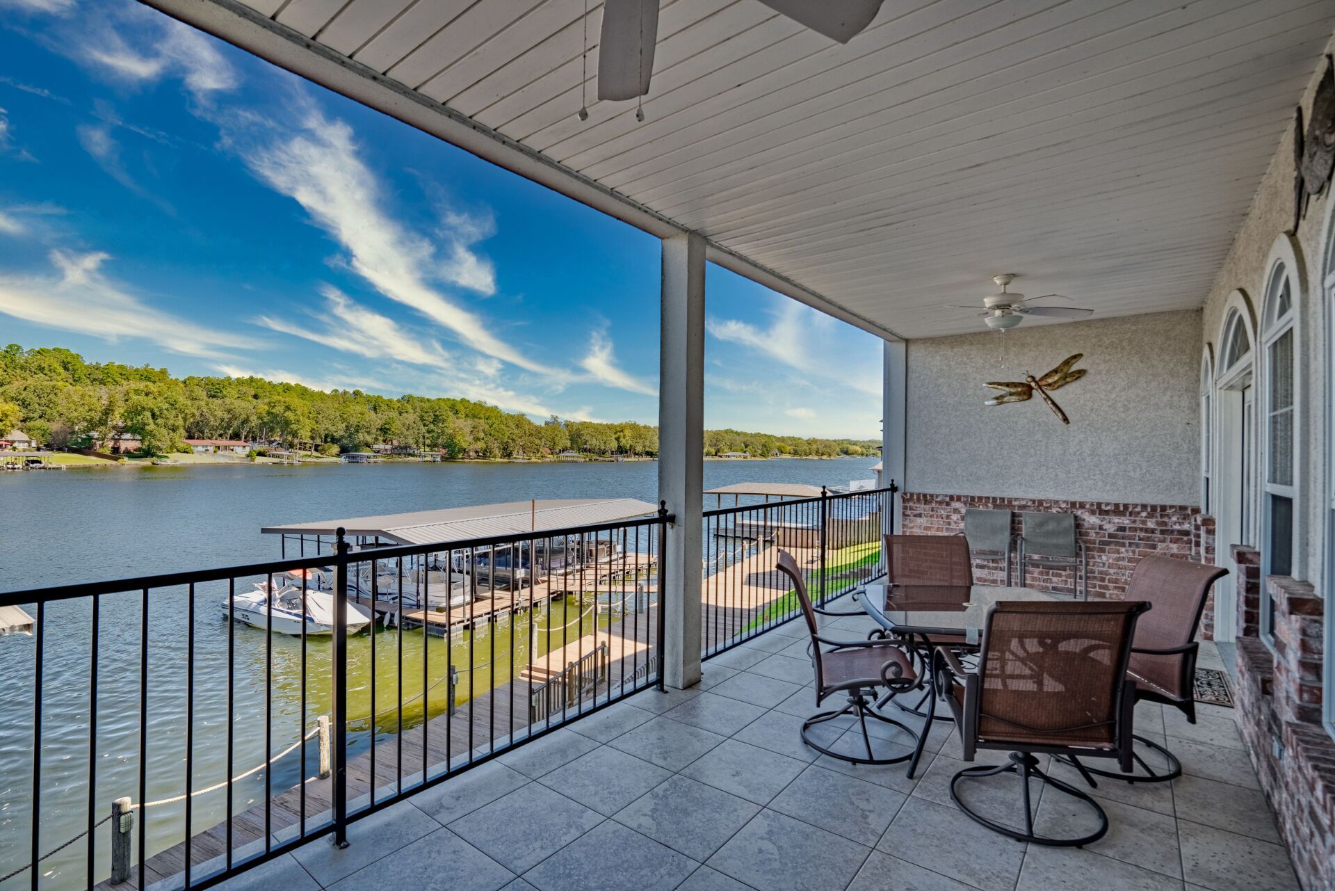 A balcony overlooking a lake with a table and chairs