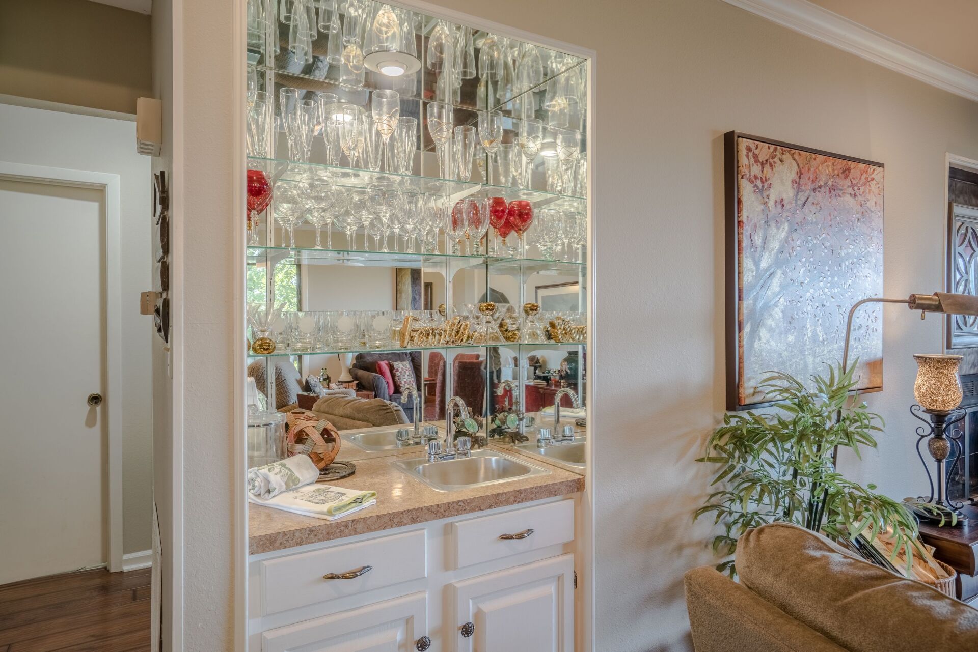 A living room with a bar and a sink in it.