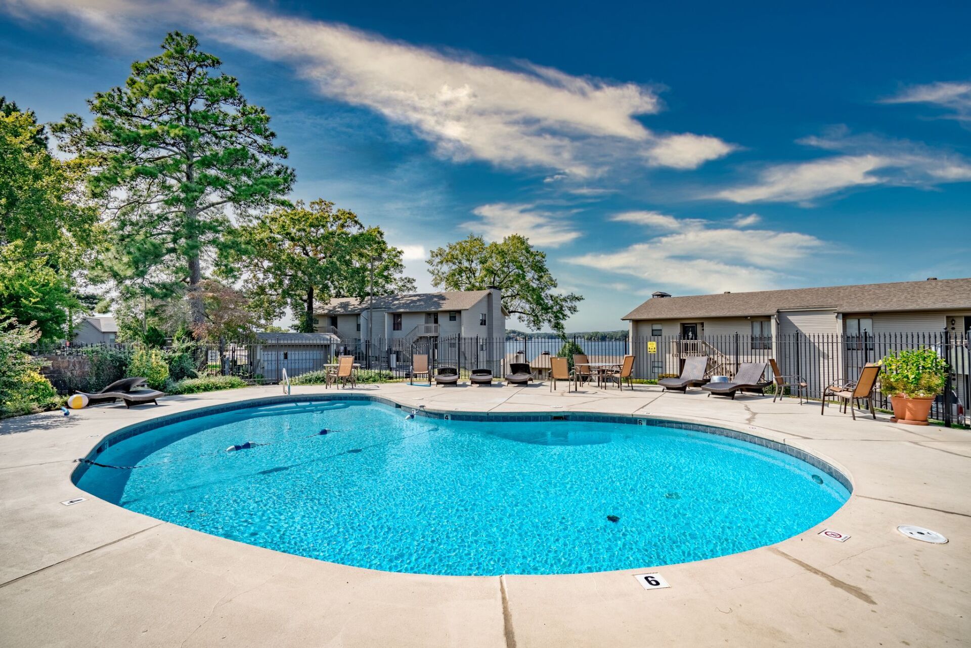 A large swimming pool with a lot of chairs around it
