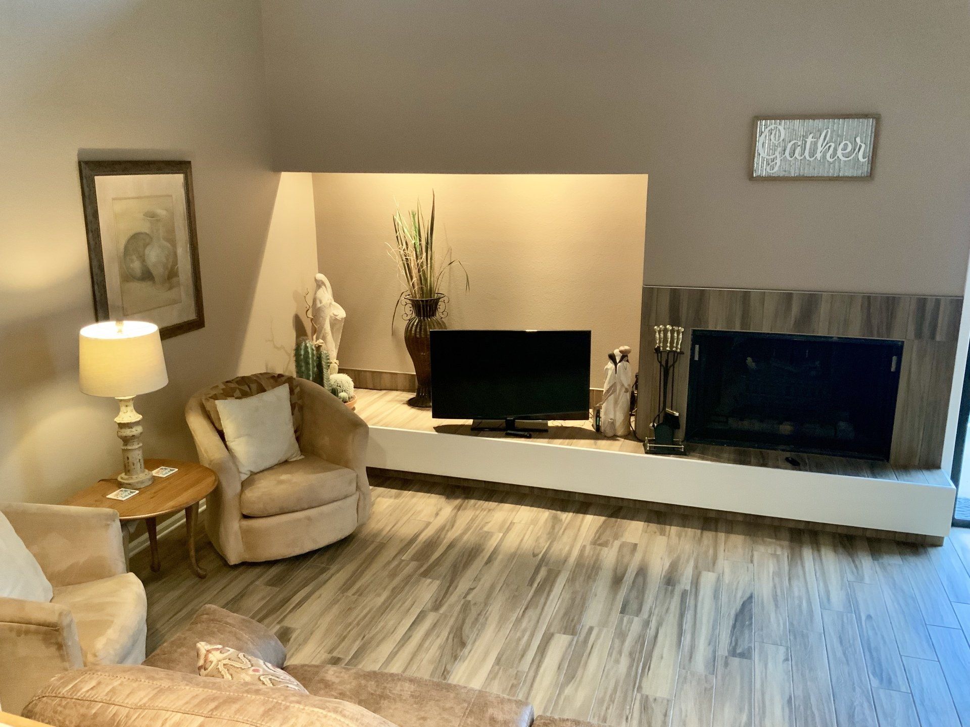 A living room with a fireplace , couch , chair and television.