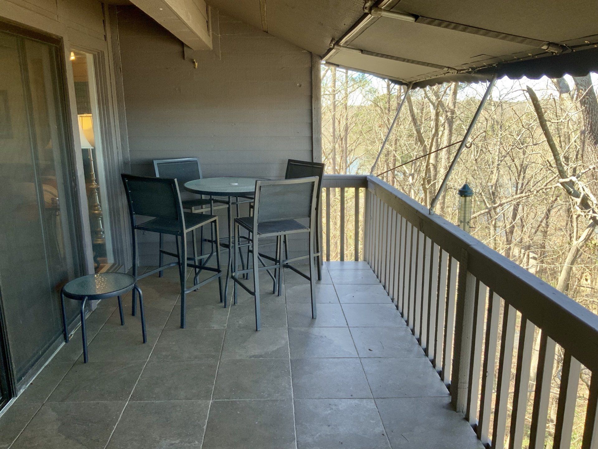 There is a balcony with a table and chairs on it.