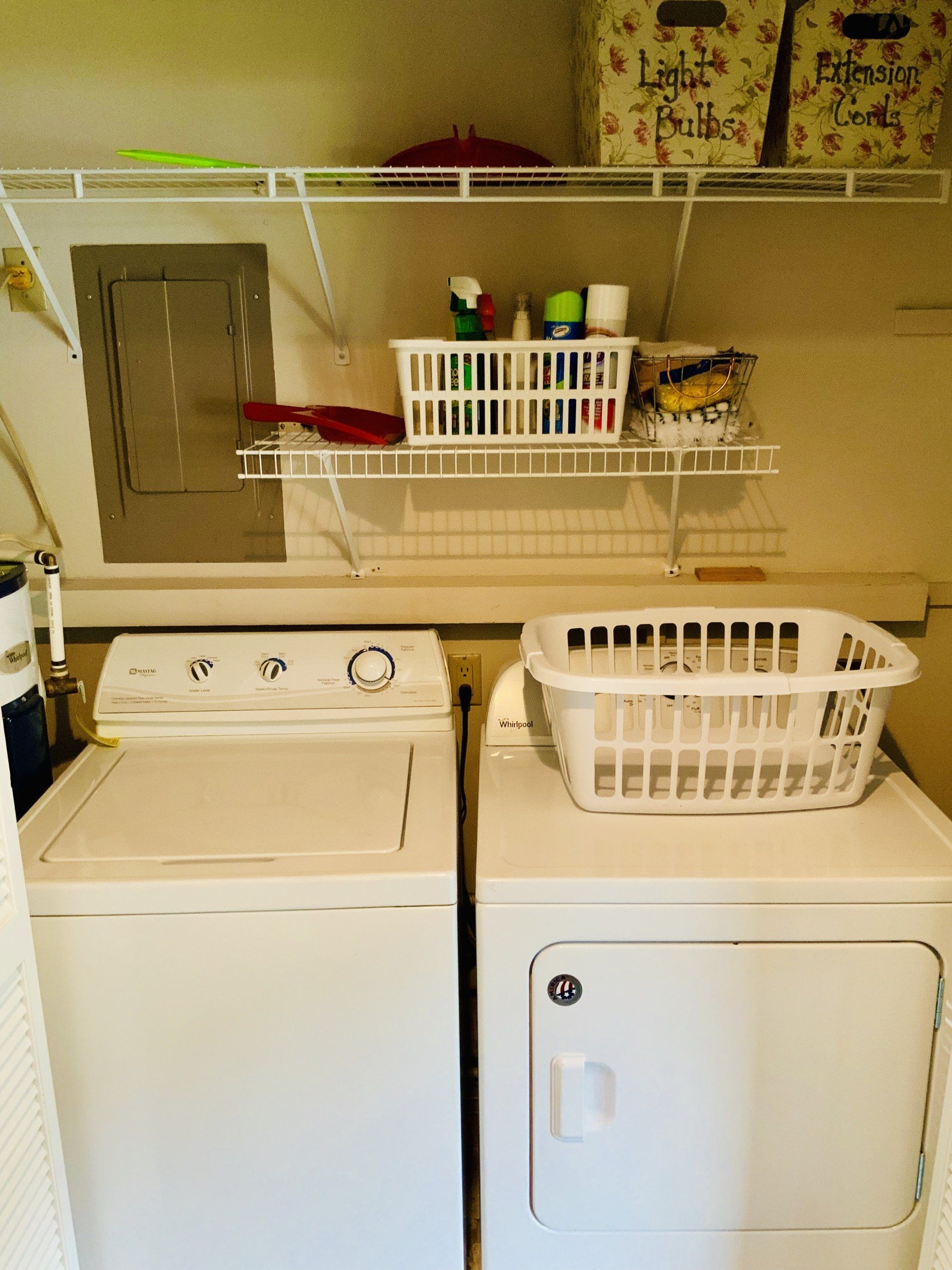 A laundry room with a washer and dryer and a basket