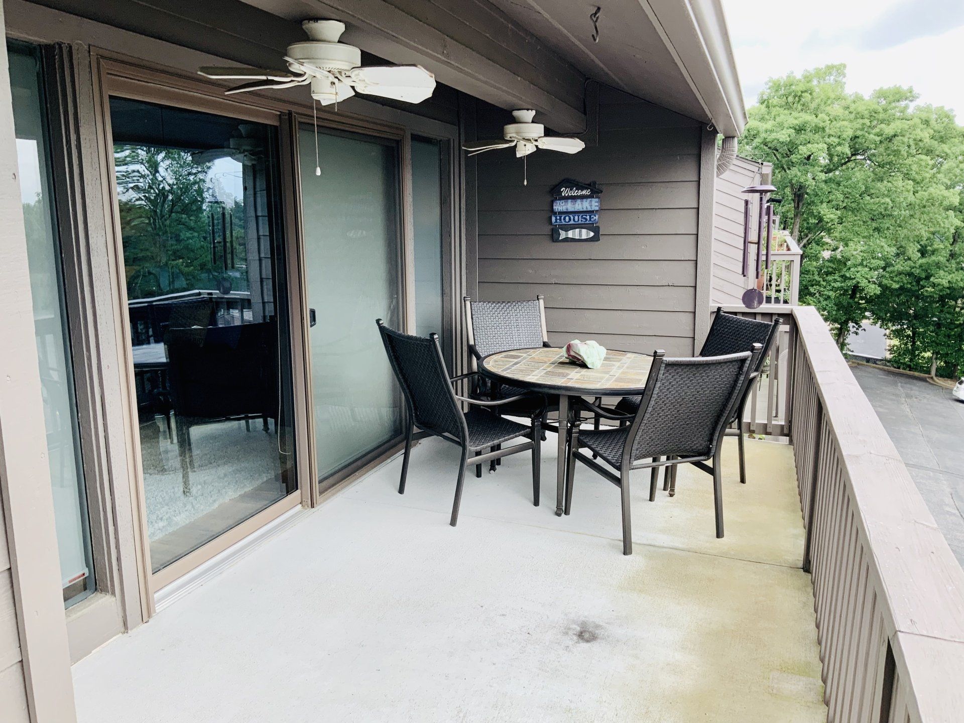 A balcony with a table and chairs and a ceiling fan