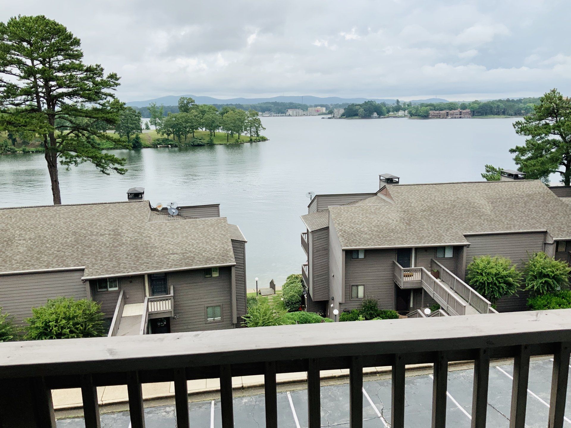 A view of a lake from a balcony with buildings in the background
