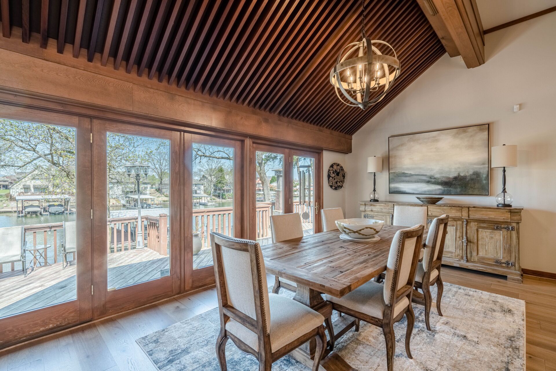 A dining room with a wooden table and chairs and a chandelier.
