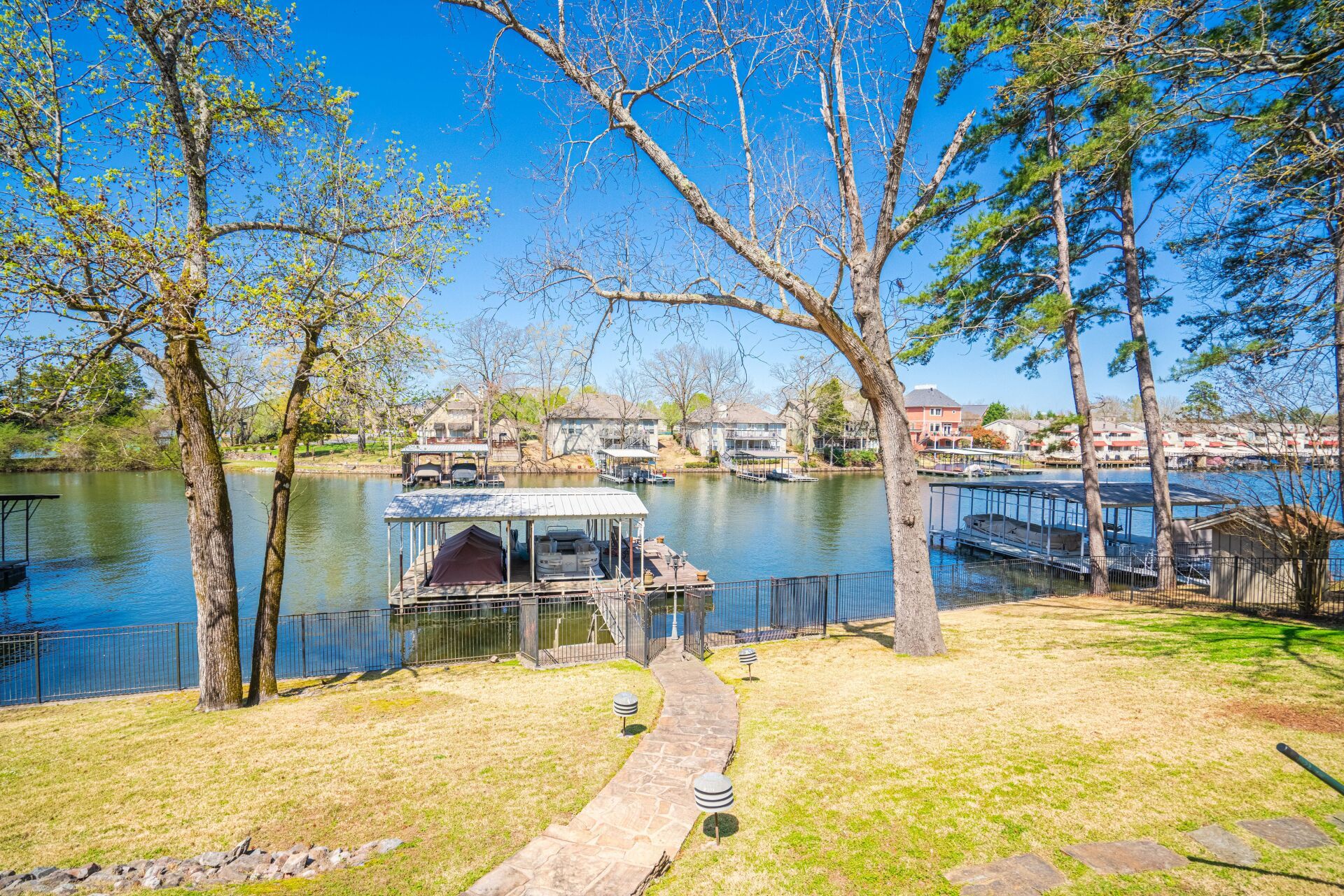 A dock with a boat docked in the middle of a lake surrounded by trees.
