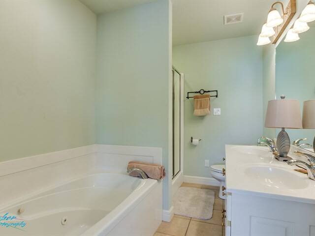 A bathroom with a tub , sink , toilet and mirror.