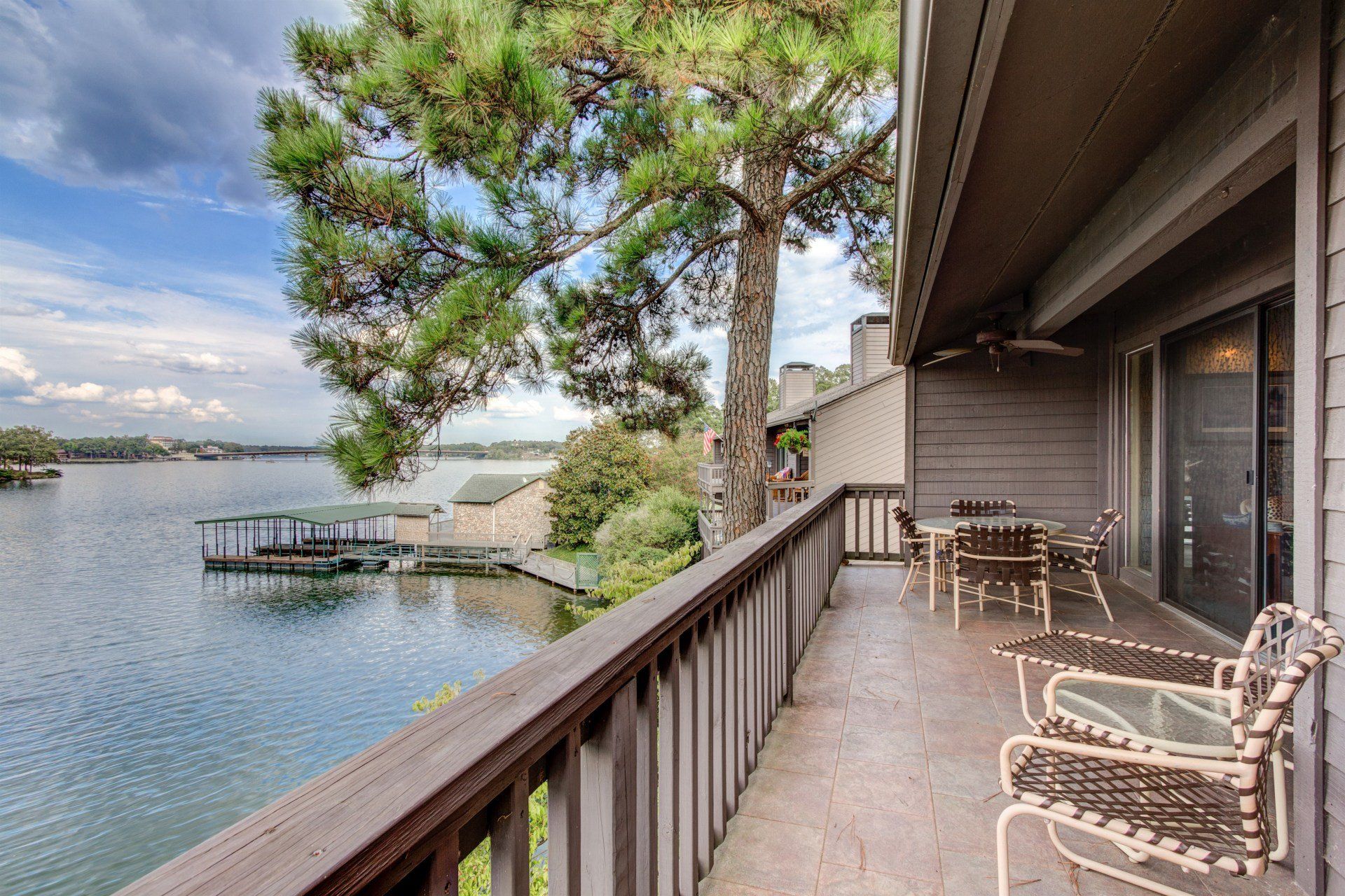 A balcony overlooking a lake with a table and chairs