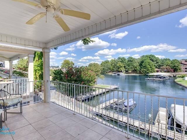 A balcony overlooking a lake with a ceiling fan