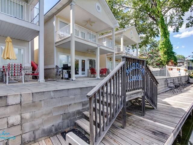 A large house with a wooden deck and stairs leading up to it.