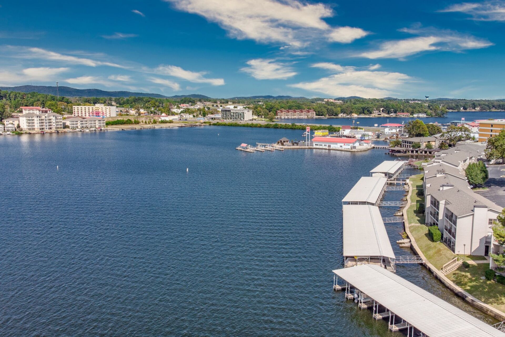 An aerial view of a lake with a lot of boats docked in it.
