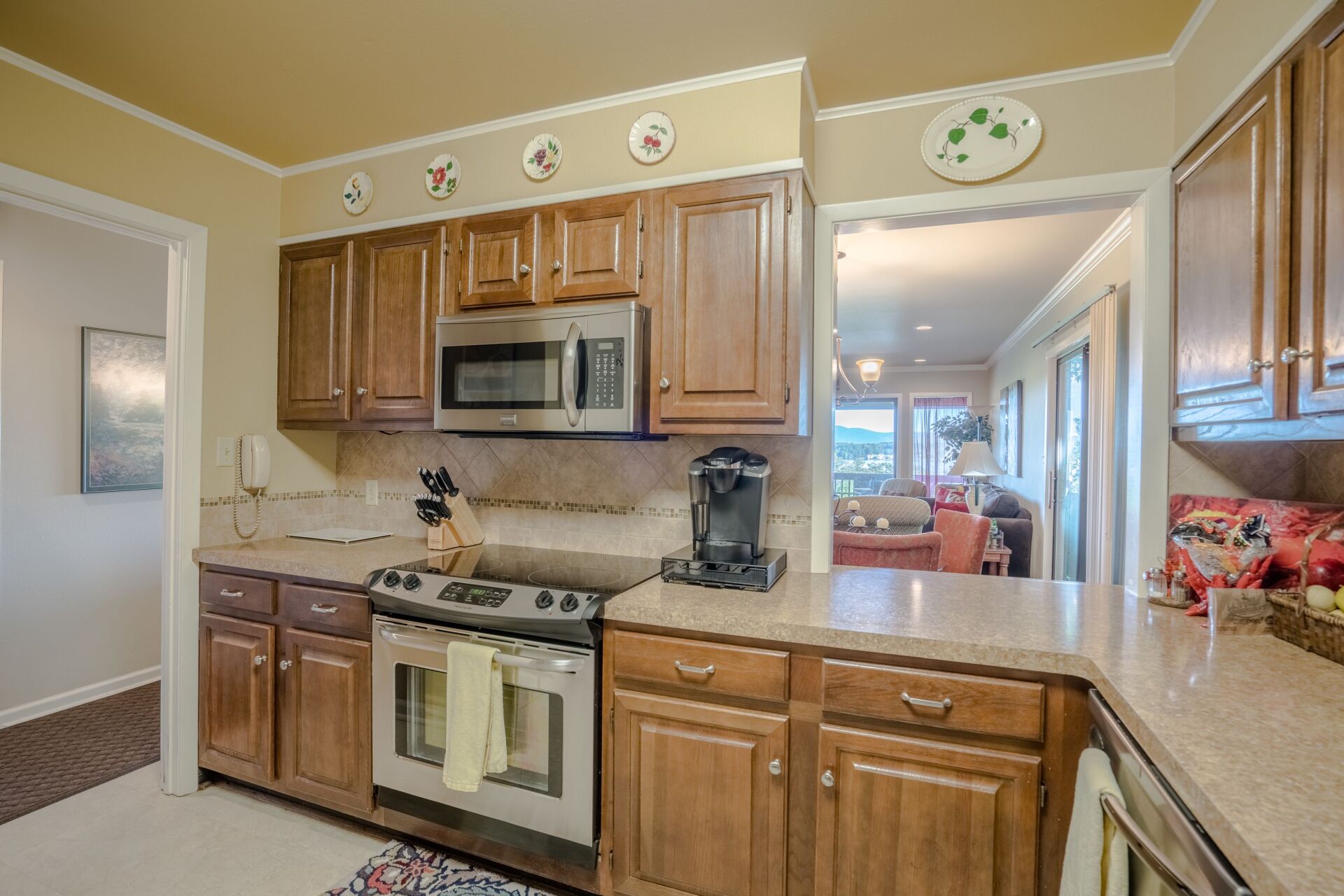 A kitchen with wooden cabinets , stainless steel appliances , and granite counter tops.