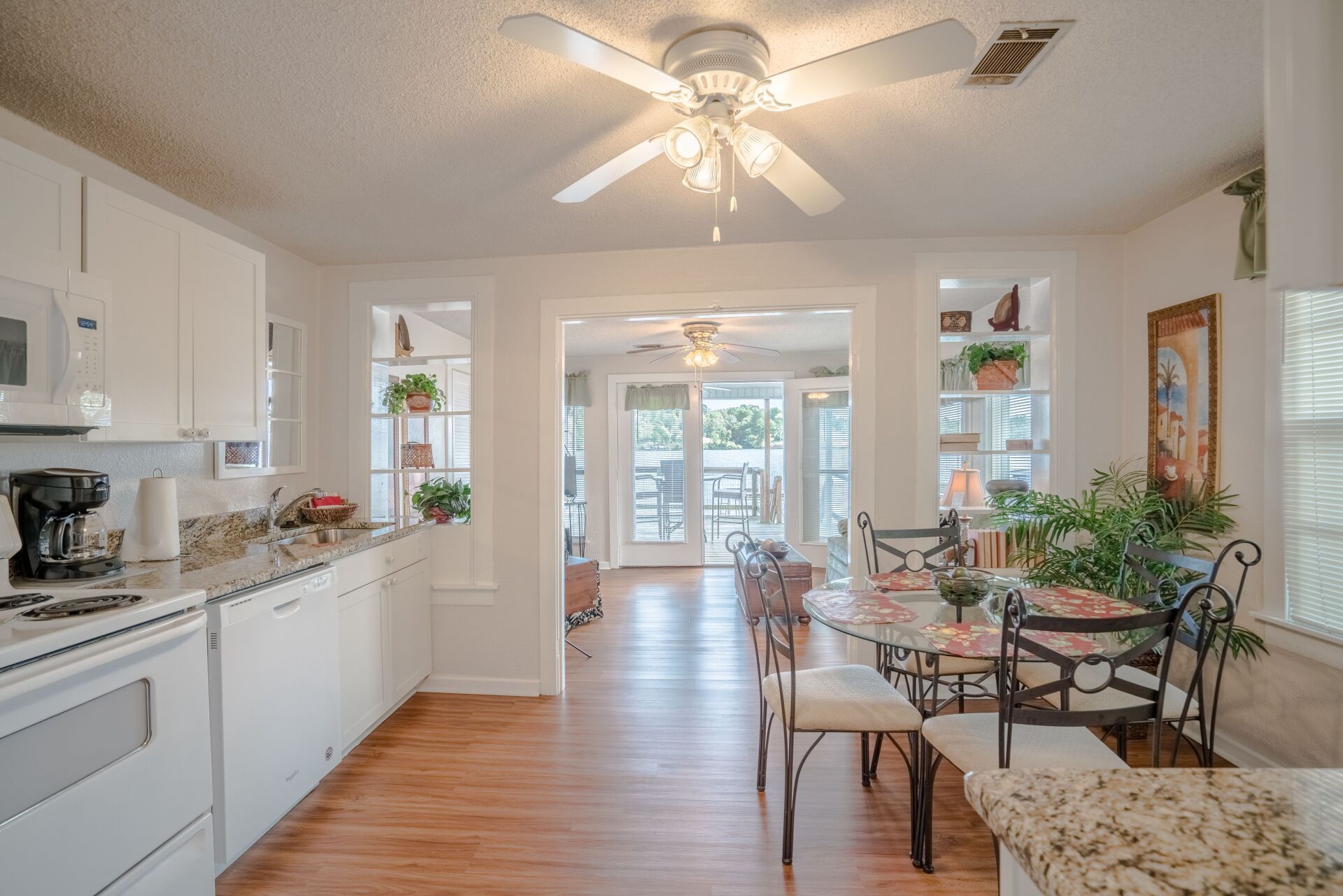 A kitchen and dining room in a house with a ceiling fan.