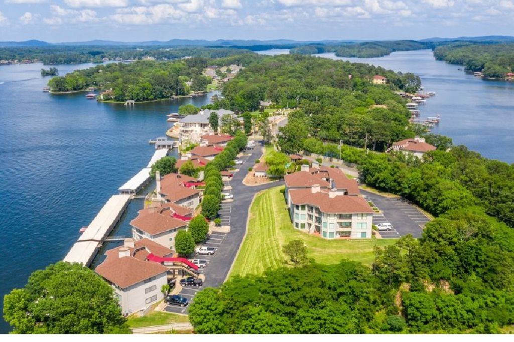 An aerial view of a lake surrounded by trees and buildings.
