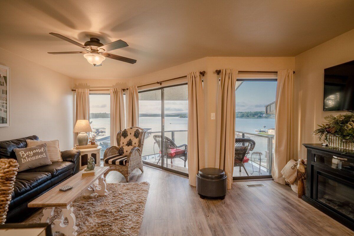 A living room with a couch , chair , fireplace and sliding glass doors.