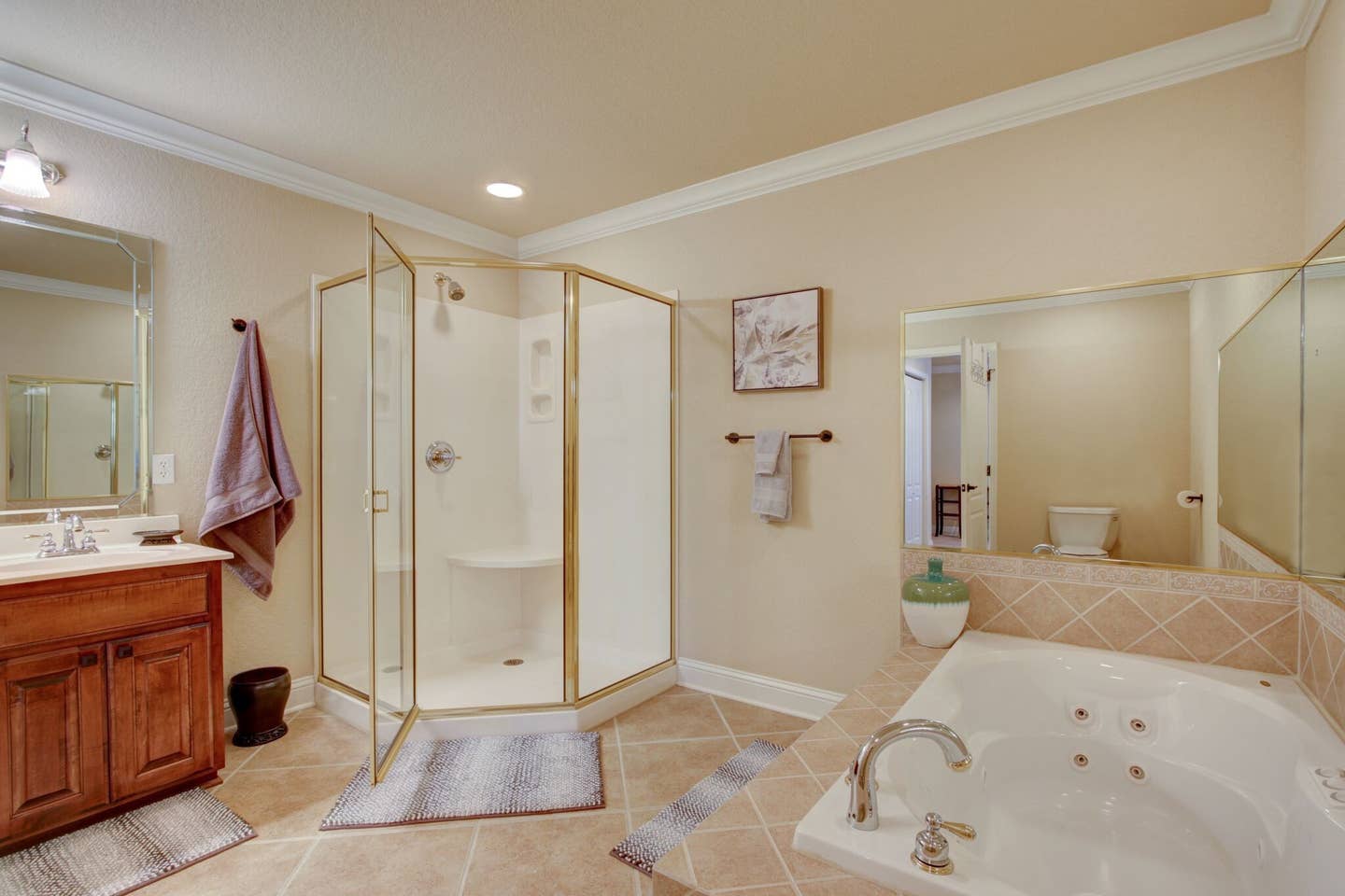 A bathroom with a tub , sink , shower and mirror.