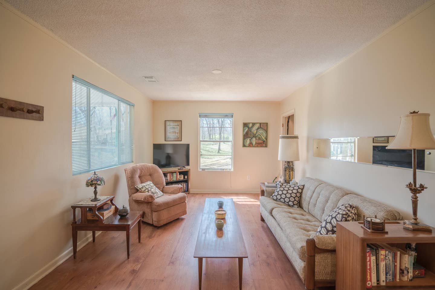 A living room with a couch , chair , table and television.
