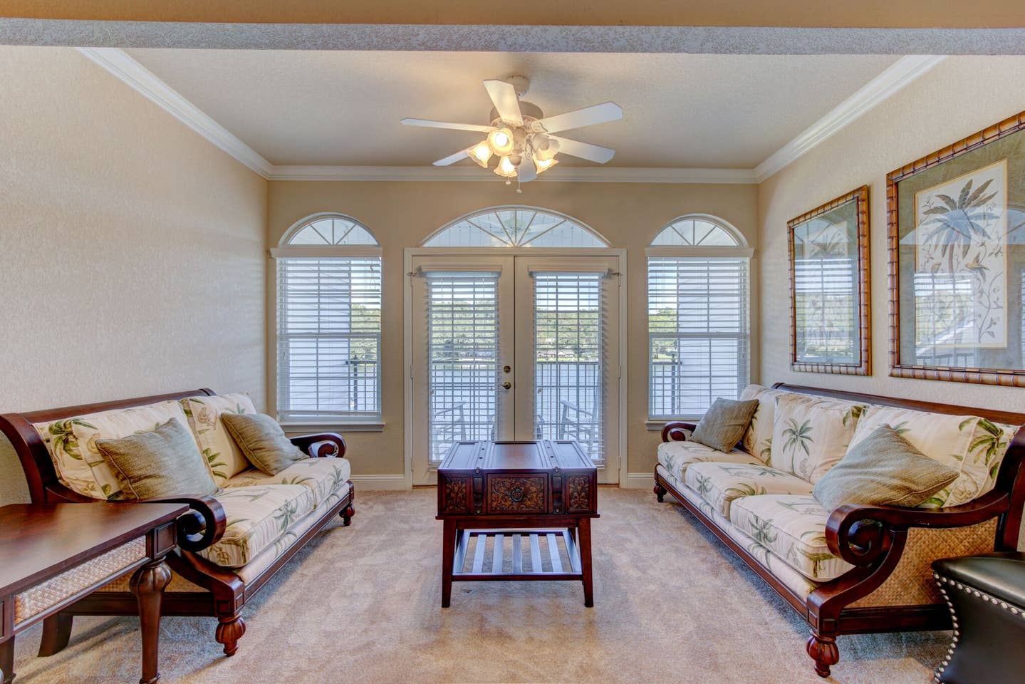 A living room with two couches , a coffee table , and a ceiling fan.