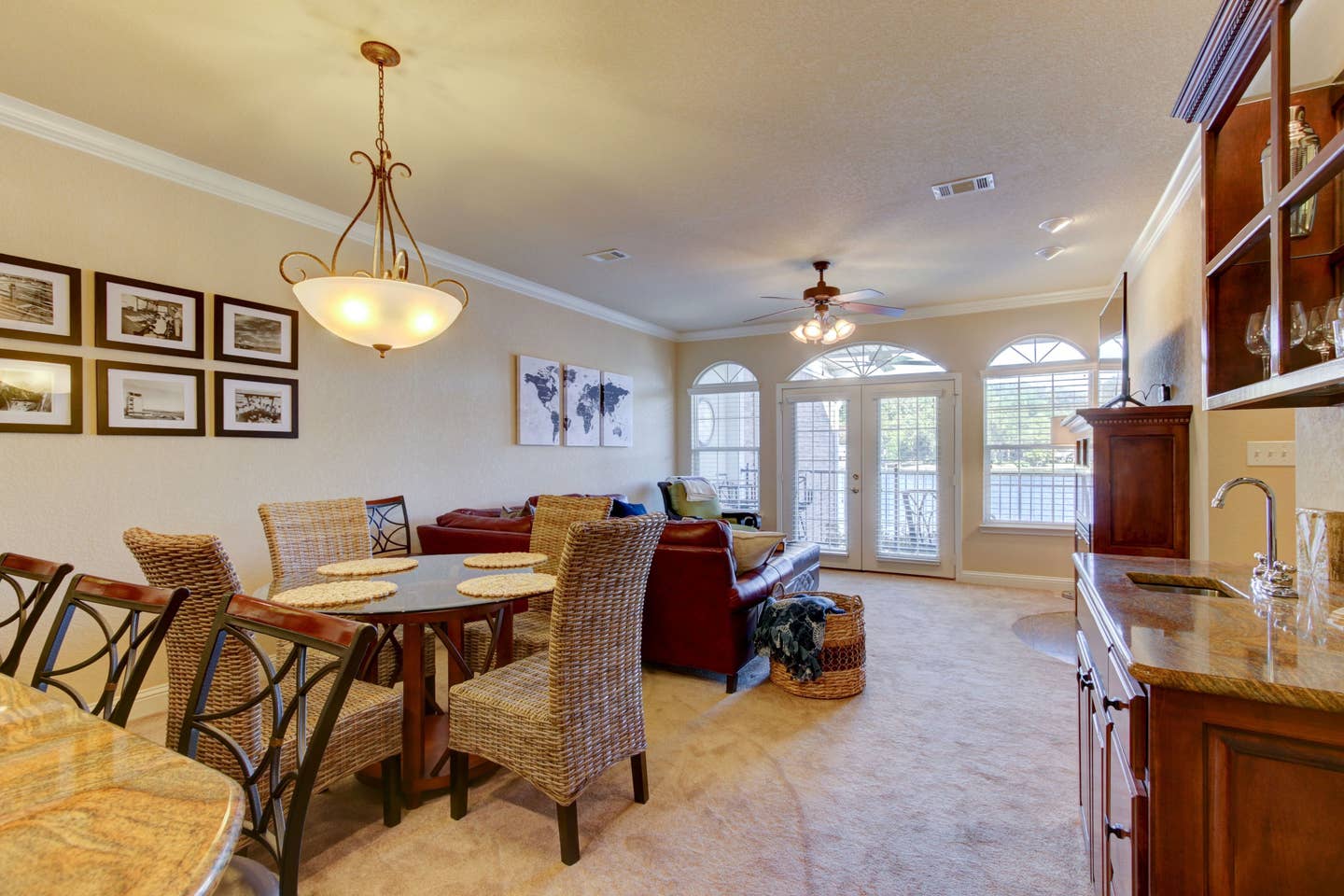 A living room with a table and chairs and a ceiling fan