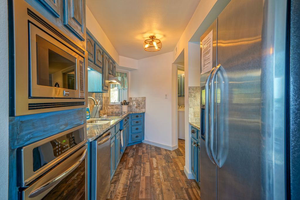 A kitchen with stainless steel appliances and blue cabinets.