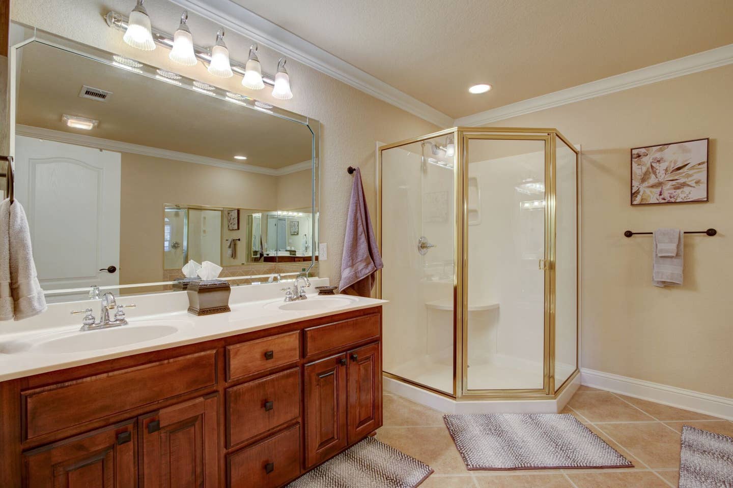 A bathroom with two sinks and a walk in shower.