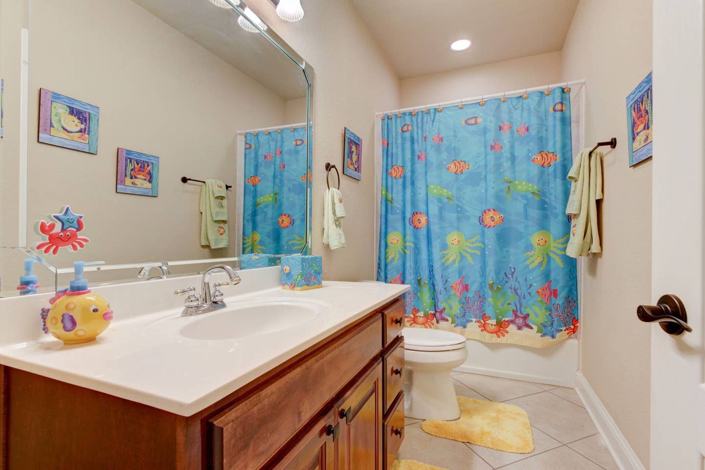A bathroom with a sink , toilet , shower curtain and mirror.