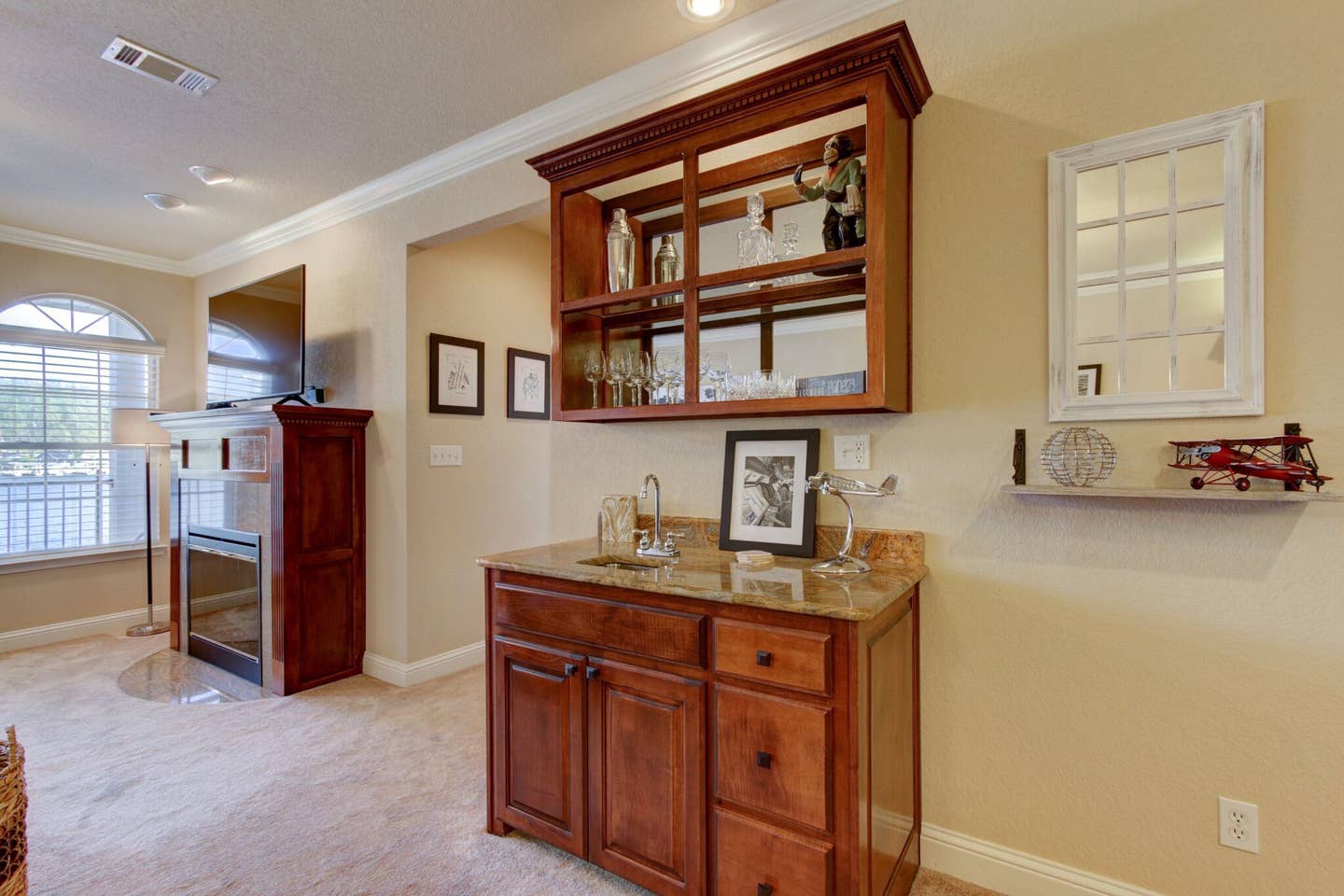 A living room with a bar and a refrigerator.