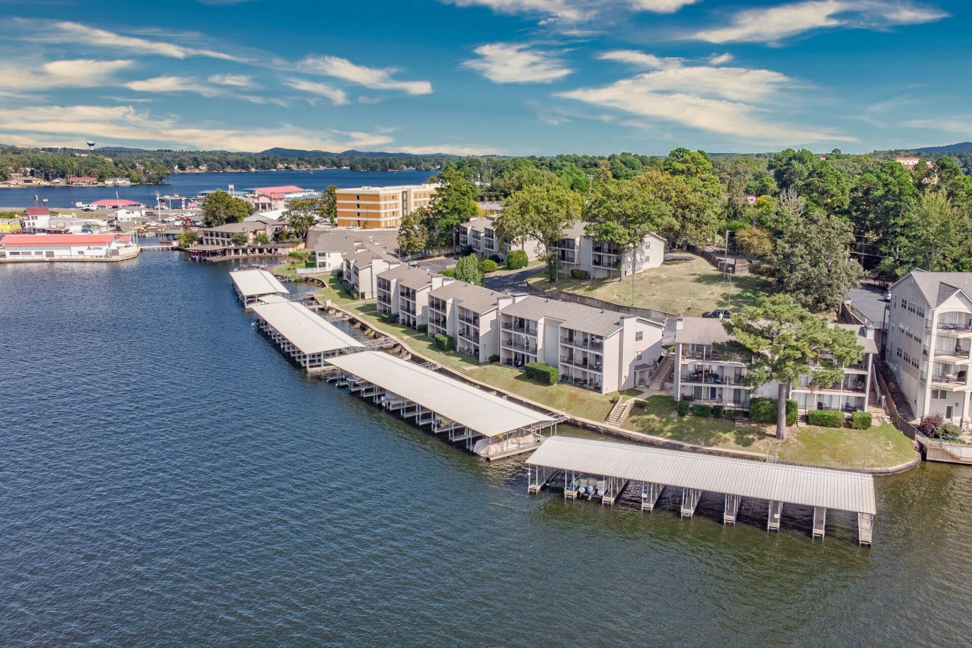 An aerial view of a lake with a row of buildings on the shore.