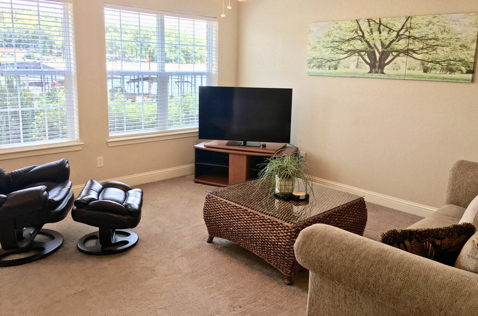 A living room with a couch , chair , coffee table and television.