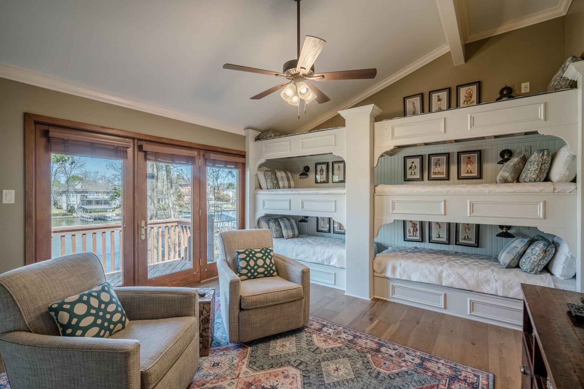 A living room with bunk beds , chairs and a ceiling fan.