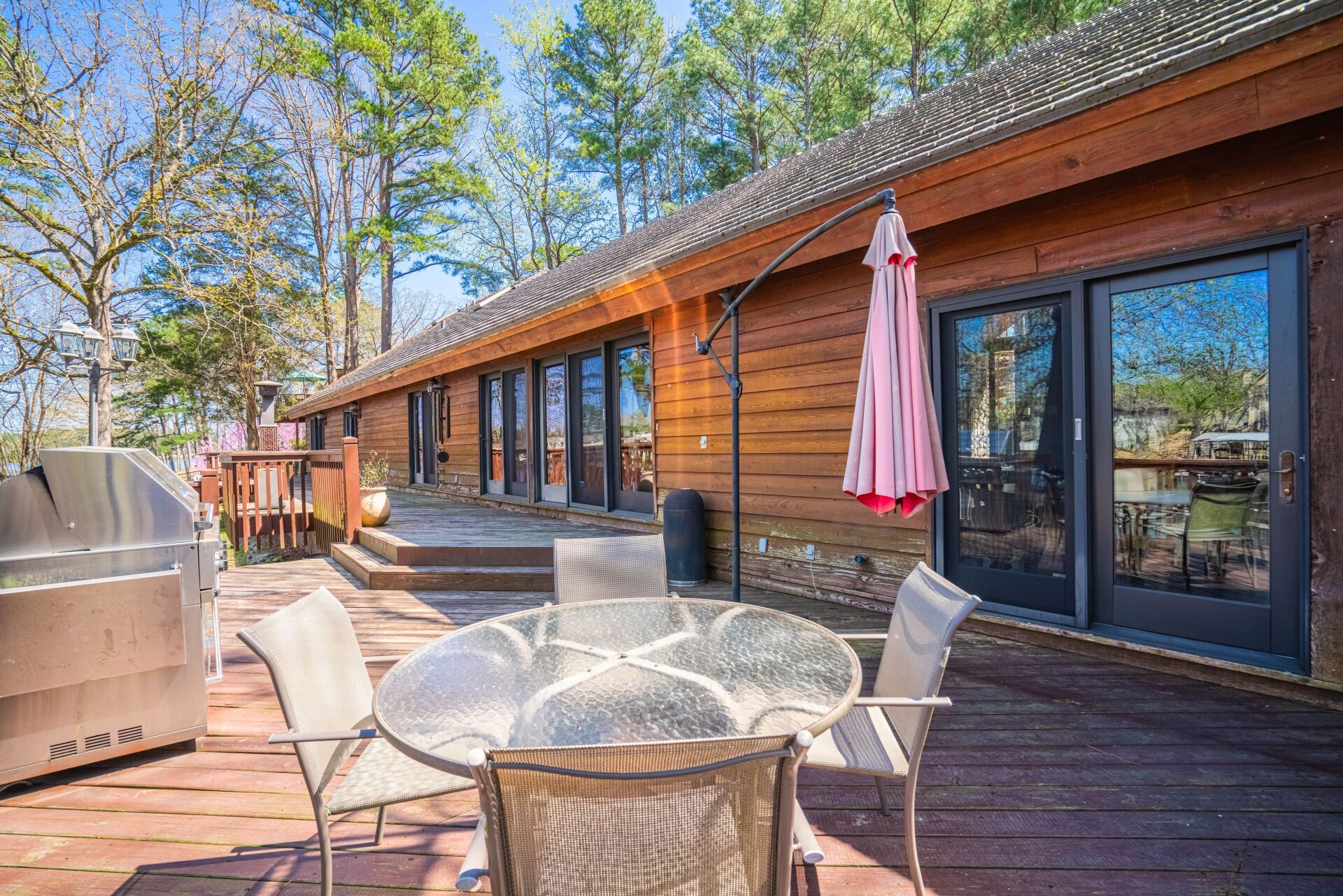There is a table and chairs on the deck of a log cabin.