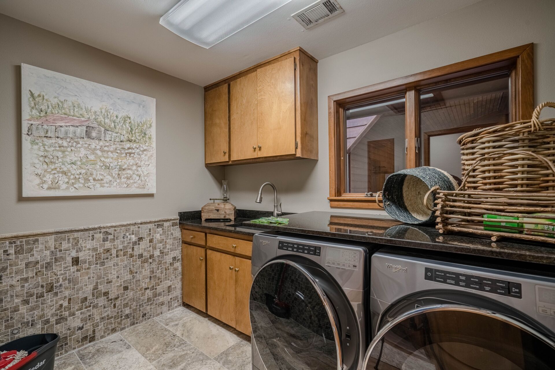 A laundry room with a washer and dryer and a window.