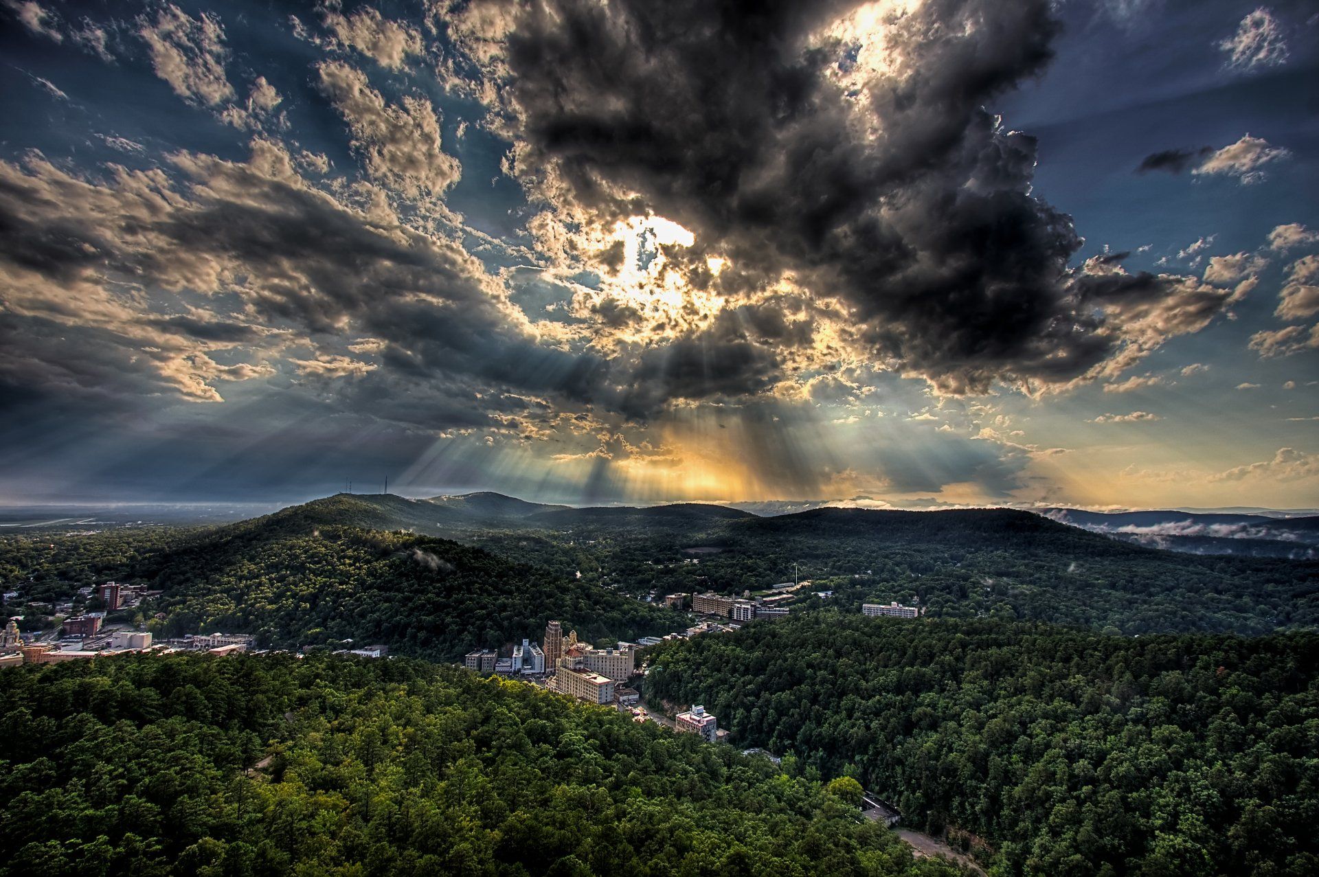 The sun is shining through the clouds over a city