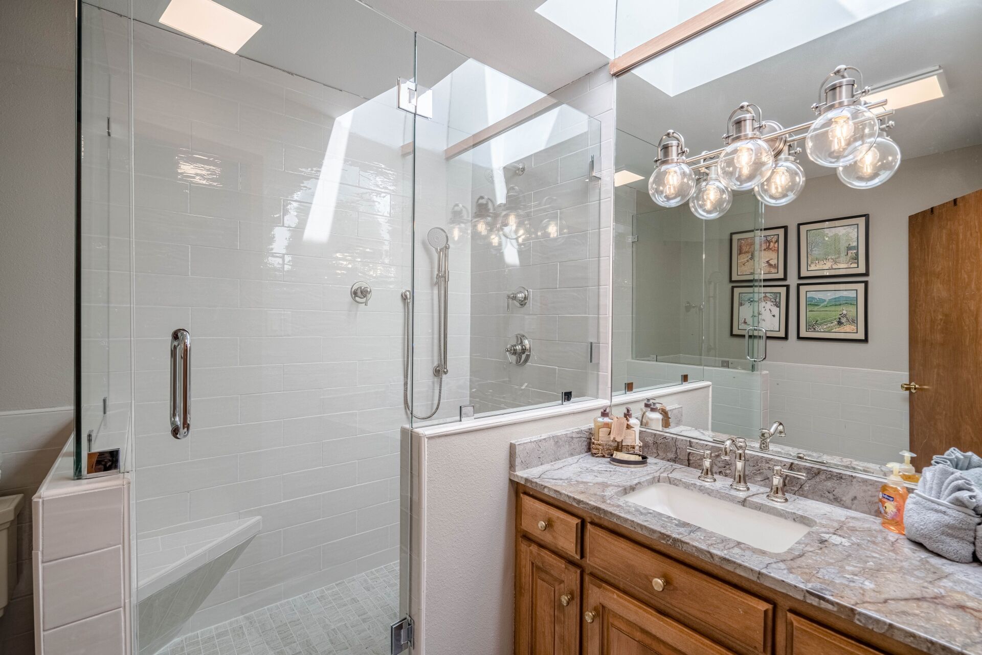 A bathroom with a walk in shower , sink , and mirror.