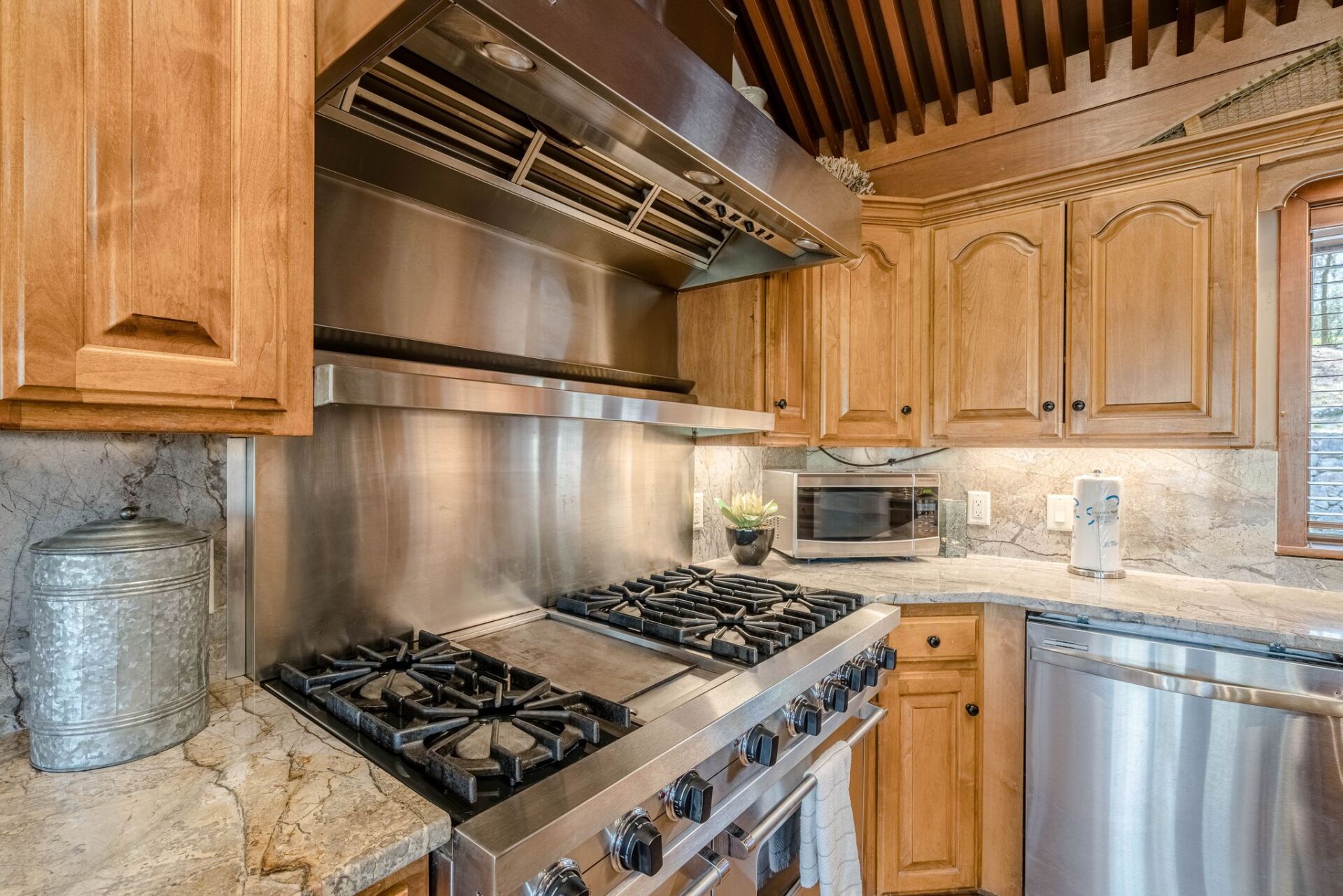 A kitchen with stainless steel appliances and wooden cabinets.