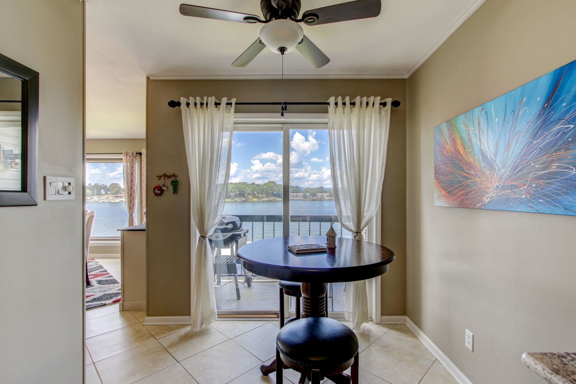 A dining room with a table and chairs and a ceiling fan.
