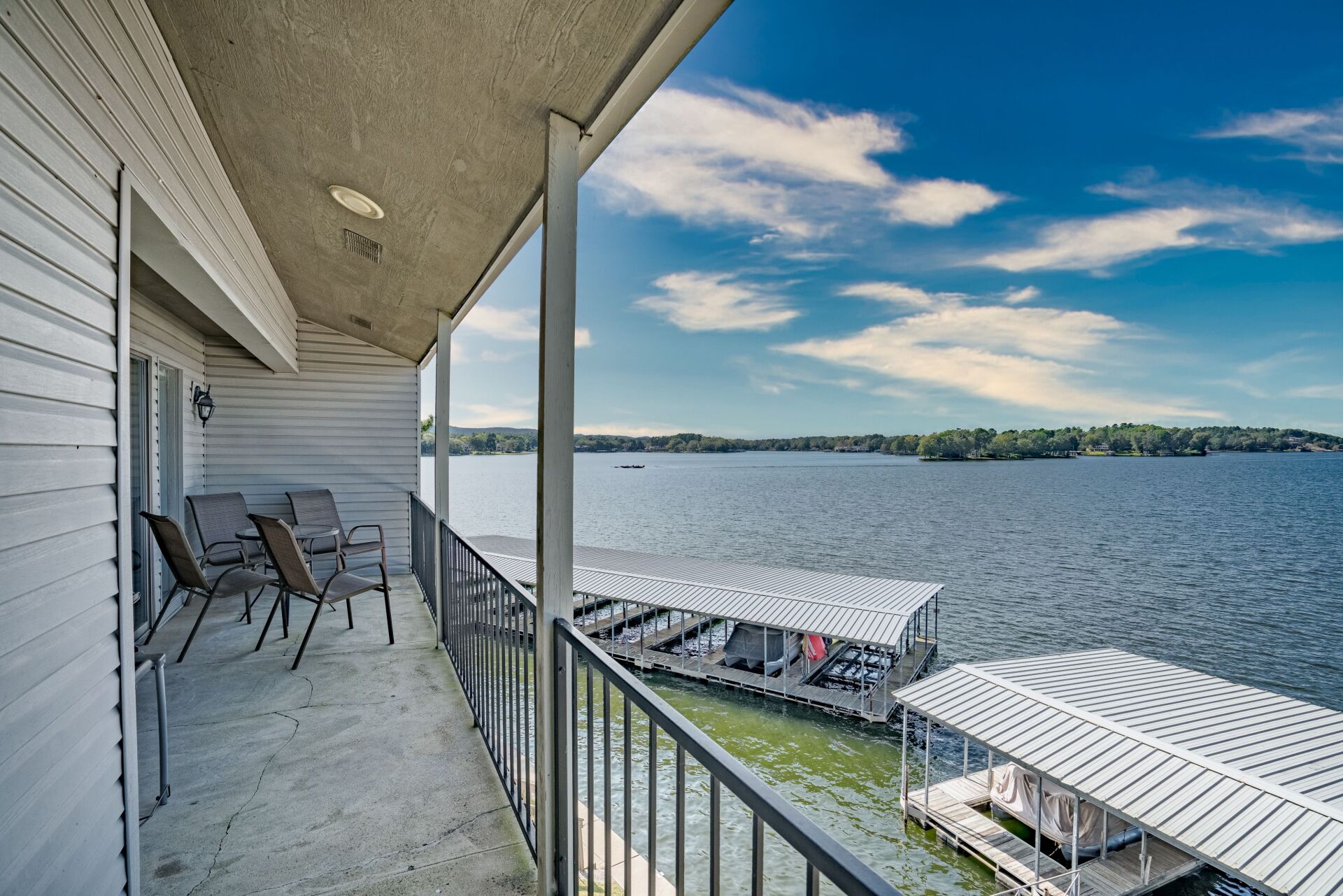 A balcony overlooking a lake with a dock in the background