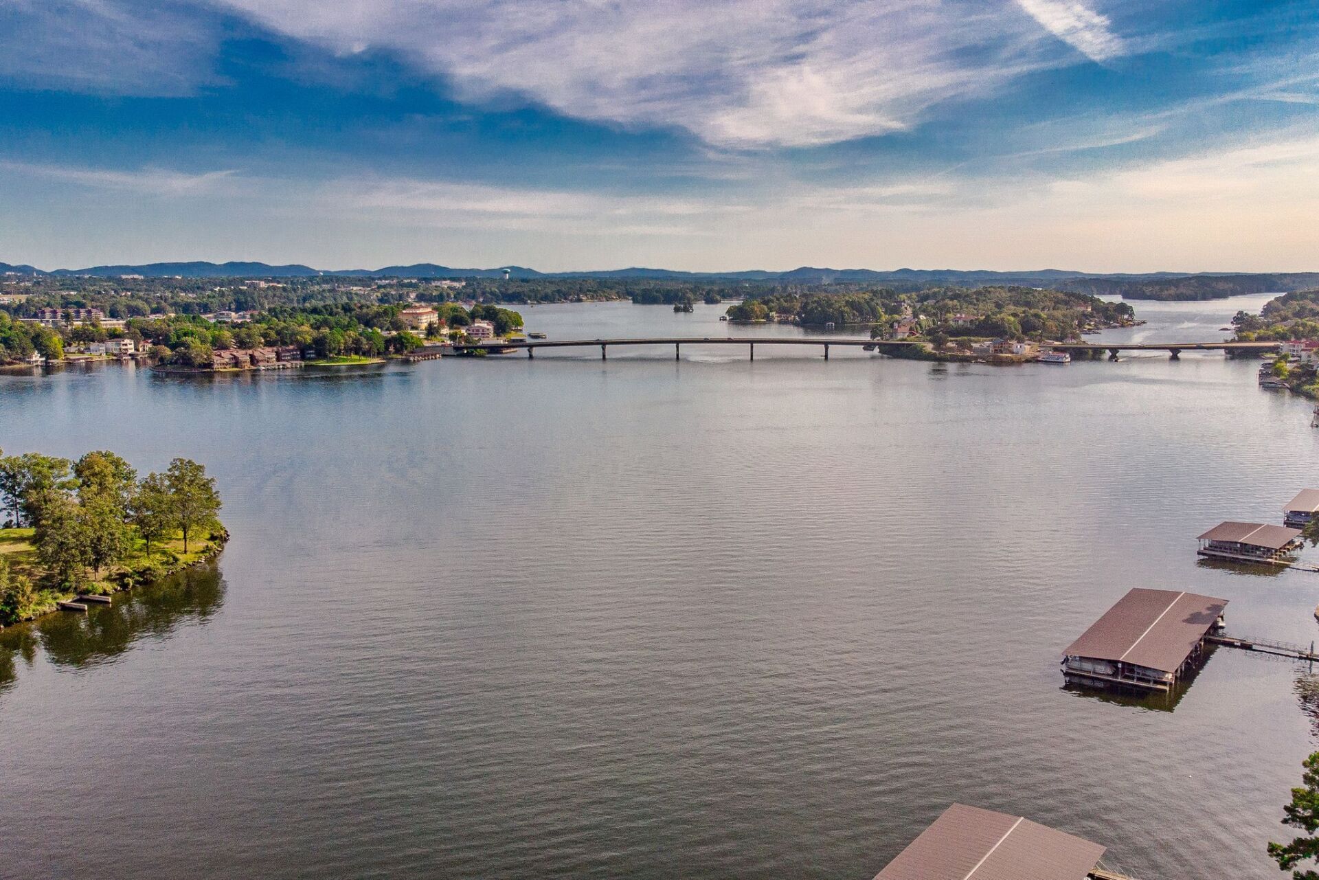 An aerial view of a large body of water with a bridge in the distance.