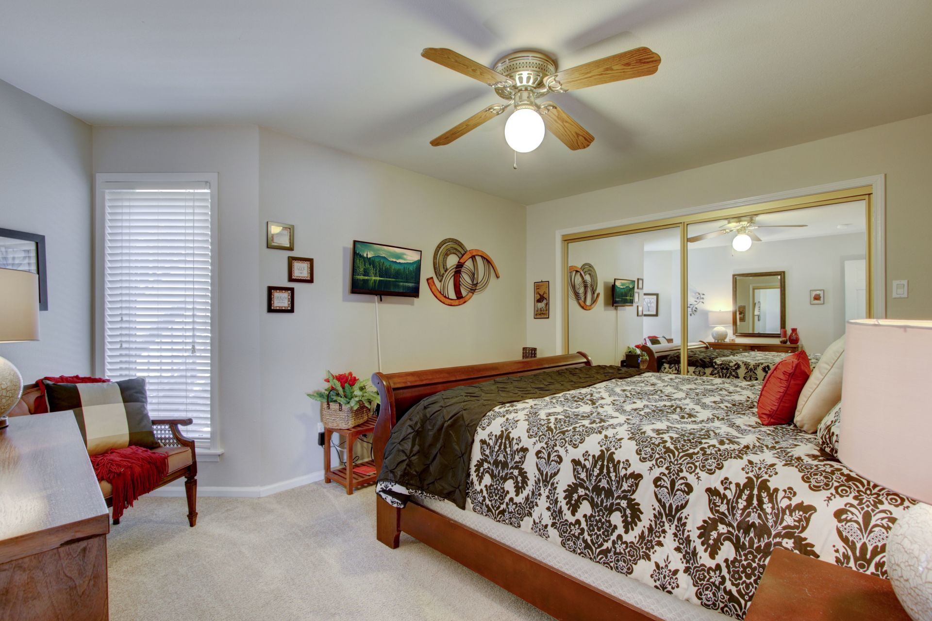 A bedroom with a large bed and a ceiling fan