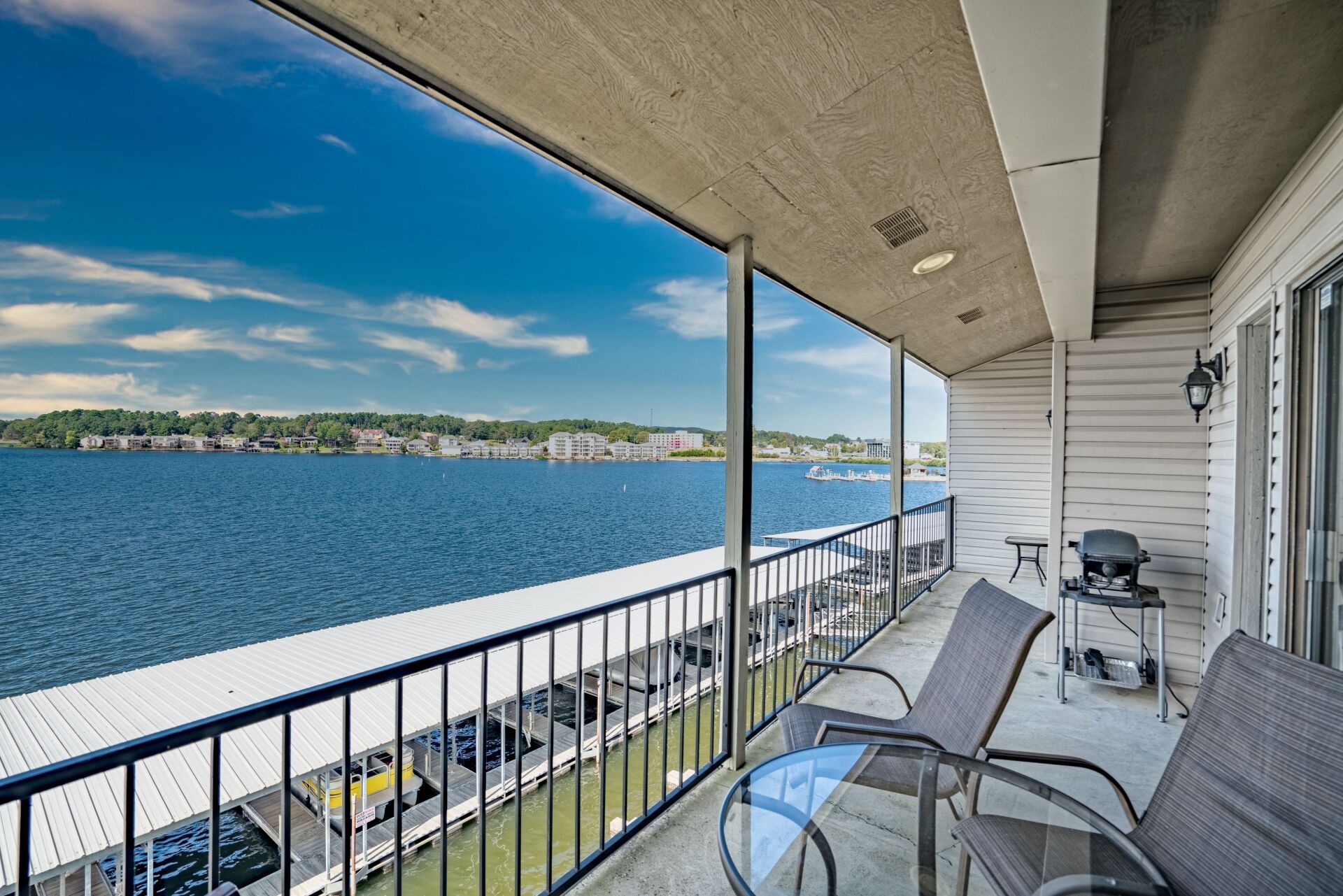 A balcony overlooking a body of water with chairs and a table