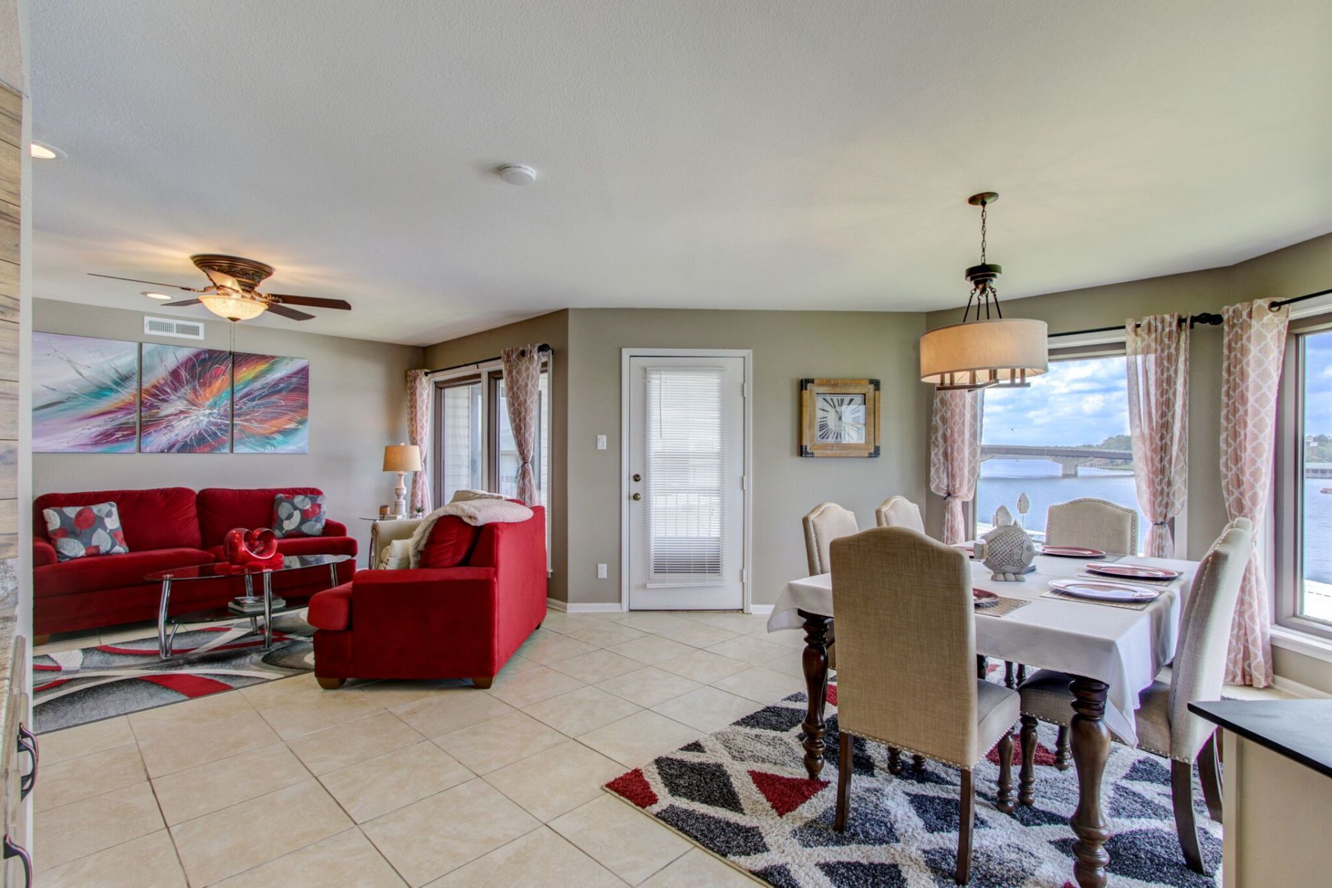 A living room with a red couch , a dining table and chairs.