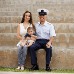 smiling couple with baby sitting on stairs for client testimonial