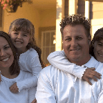 A man and a woman are posing for a picture with two little girls.