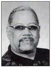 A black and white photo of a man wearing glasses and a beard.