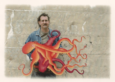 Nick Vidakovic holding an intricate Intarsia Wood art piece of a red octopus